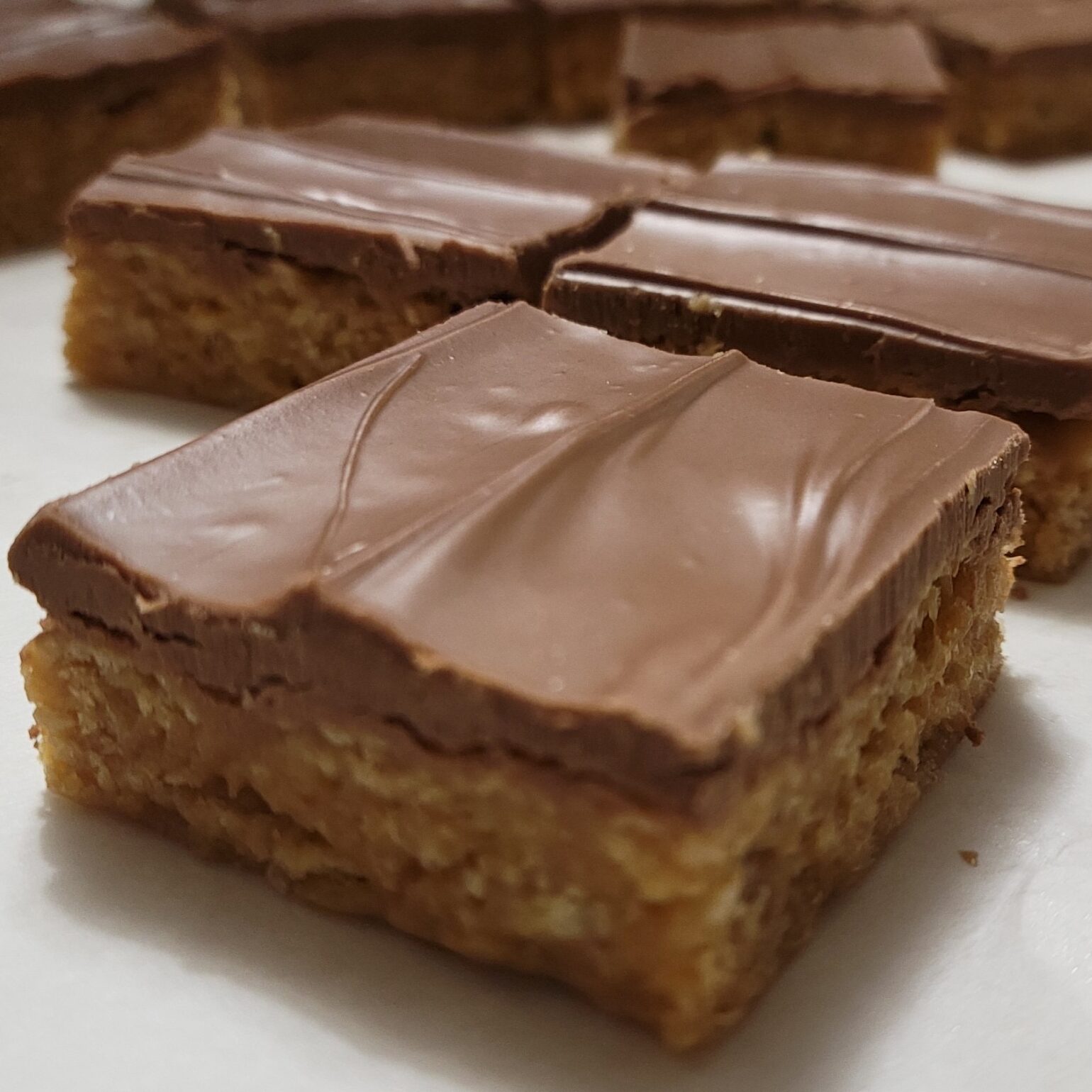 Scotcheroos, featuring crispy rice cereal mixed with a chewy peanut butter base, topped with a smooth chocolate -butterscotch layer. These handmade, no-bake treats are perfect for sweet lovers, gifting, and indulging in a nostalgic dessert experience