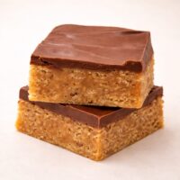 Stacked Scotcheroo bars with thick chocolate and butterscotch topping over chewy peanut butter cereal base