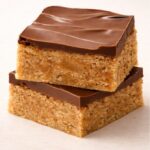 Stacked Scotcheroo bars with thick chocolate and butterscotch topping over chewy peanut butter cereal base