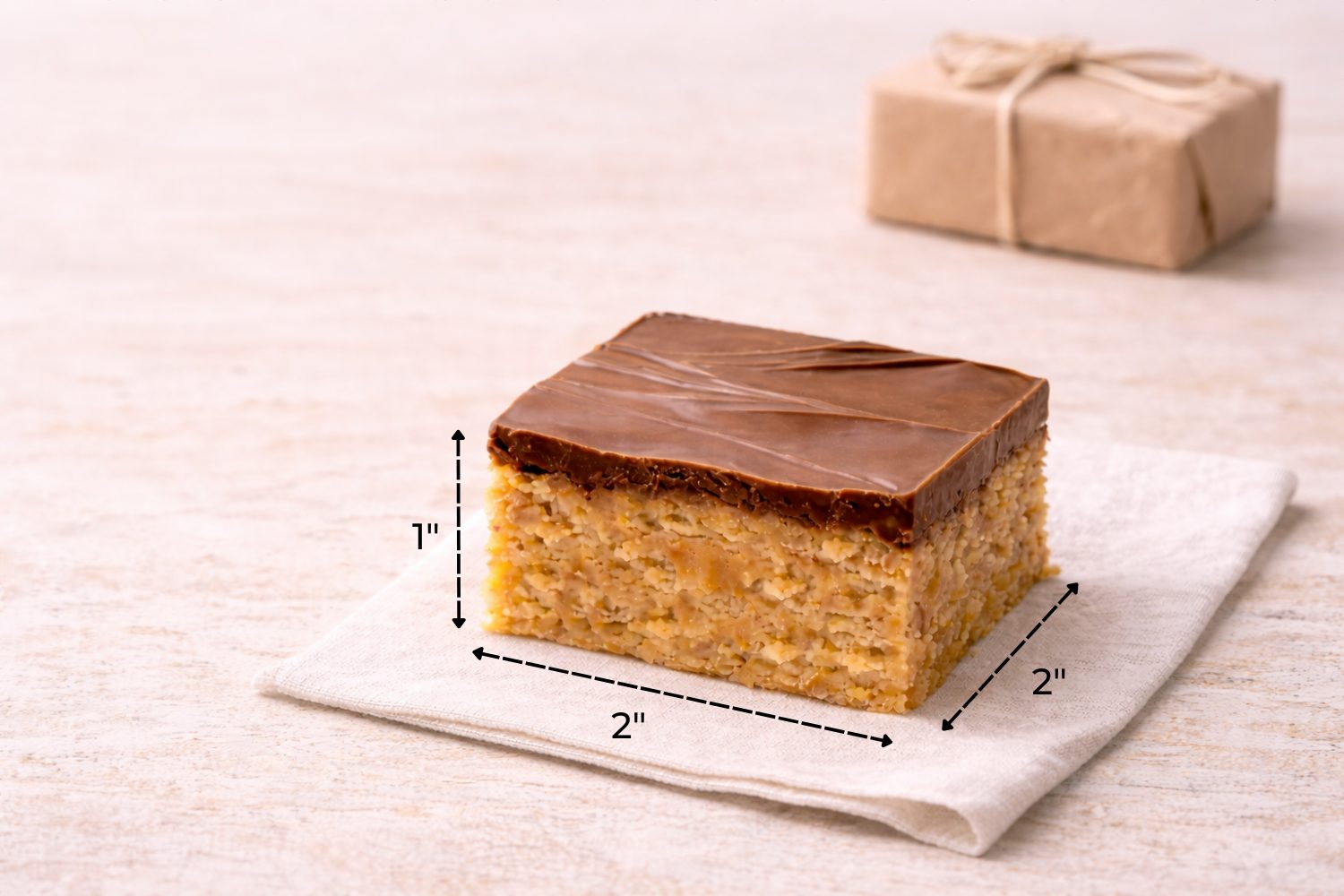 Size reference showing a 2x2 inch Scotcheroo bar with 1 inch height, layered peanut butter cereal base topped with thick chocolate and butterscotch. {{brizy_dc_image_alt imageSrc=