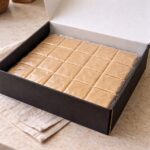 Open black gift box filled with vacuum sealed Scotcheroo bars arranged in neat squares, packaged for fresh nationwide shipping for dessert gift delivery