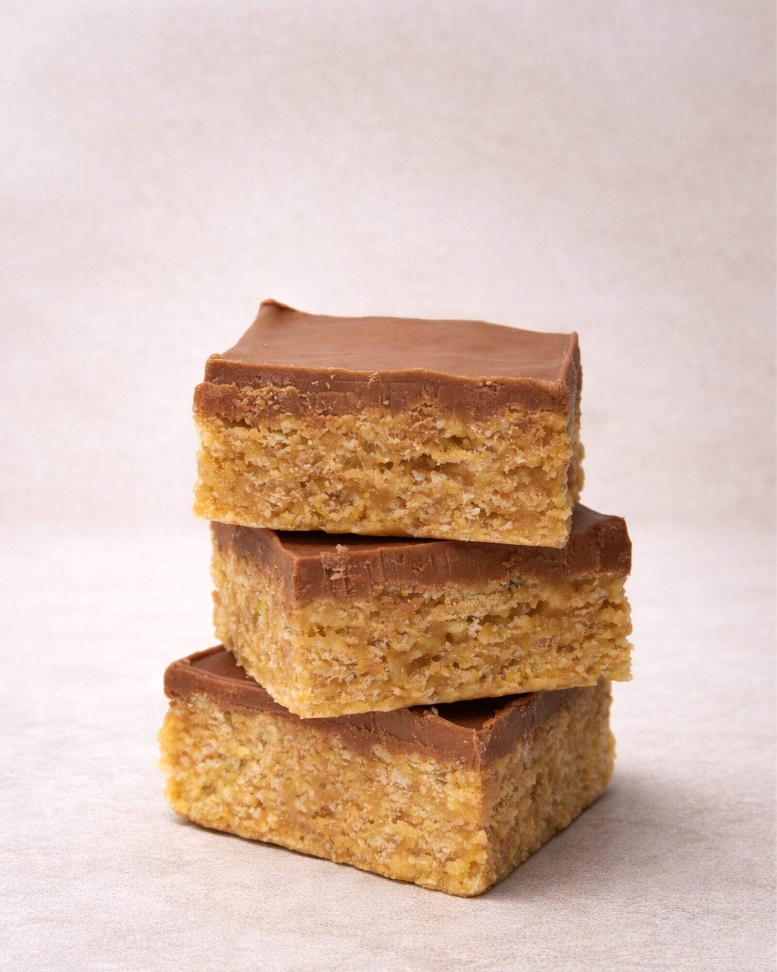 Handcrafted Scotcheroo bars with peanut butter, chocolate, and butterscotch stacked for a dessert subscription box delivery.