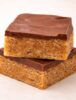 Stacked Scotcheroo bars with thick chocolate and butterscotch topping over chewy peanut butter cereal base {{brizy_dc_image_alt imageSrc=
